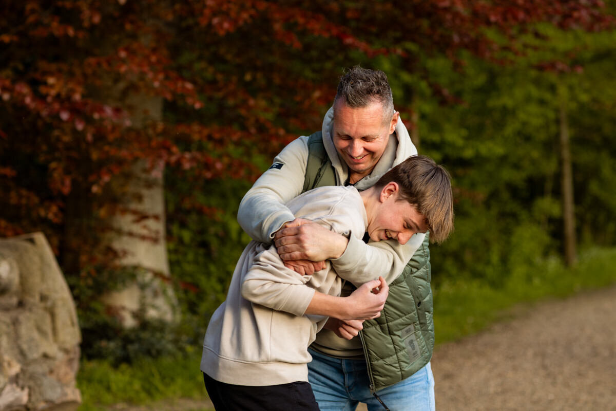 gezinsfoto vader en zoon stoeien park Elsloo