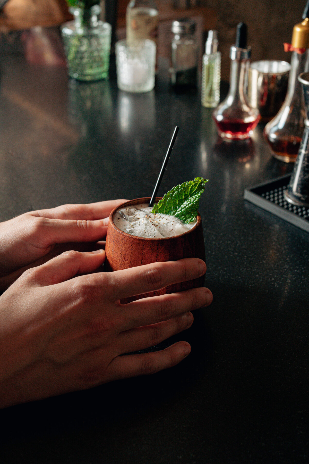Food and Beverage photography in Asheville, NC featuring hands holding a drink with a mint leaf