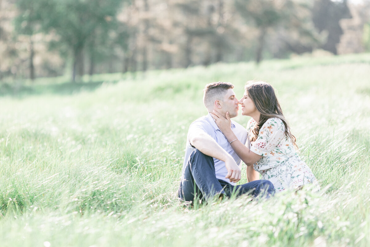 Couple pressing noses together during sunset for engagement pictures in a field in Saratoga, NY