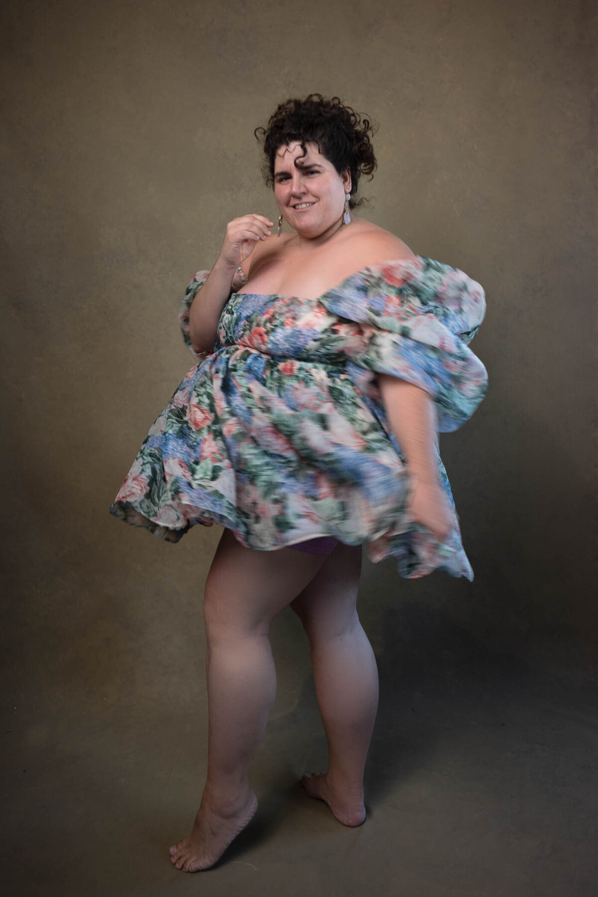 Woman dancing in front on the camera wearing a short flower dress