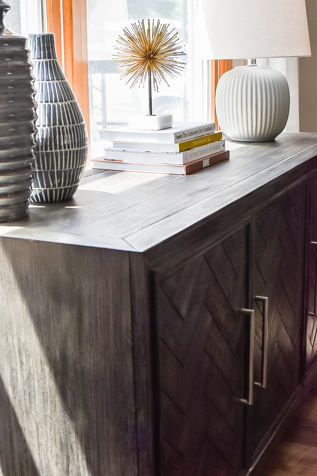 A storage console sits in front of a bright window