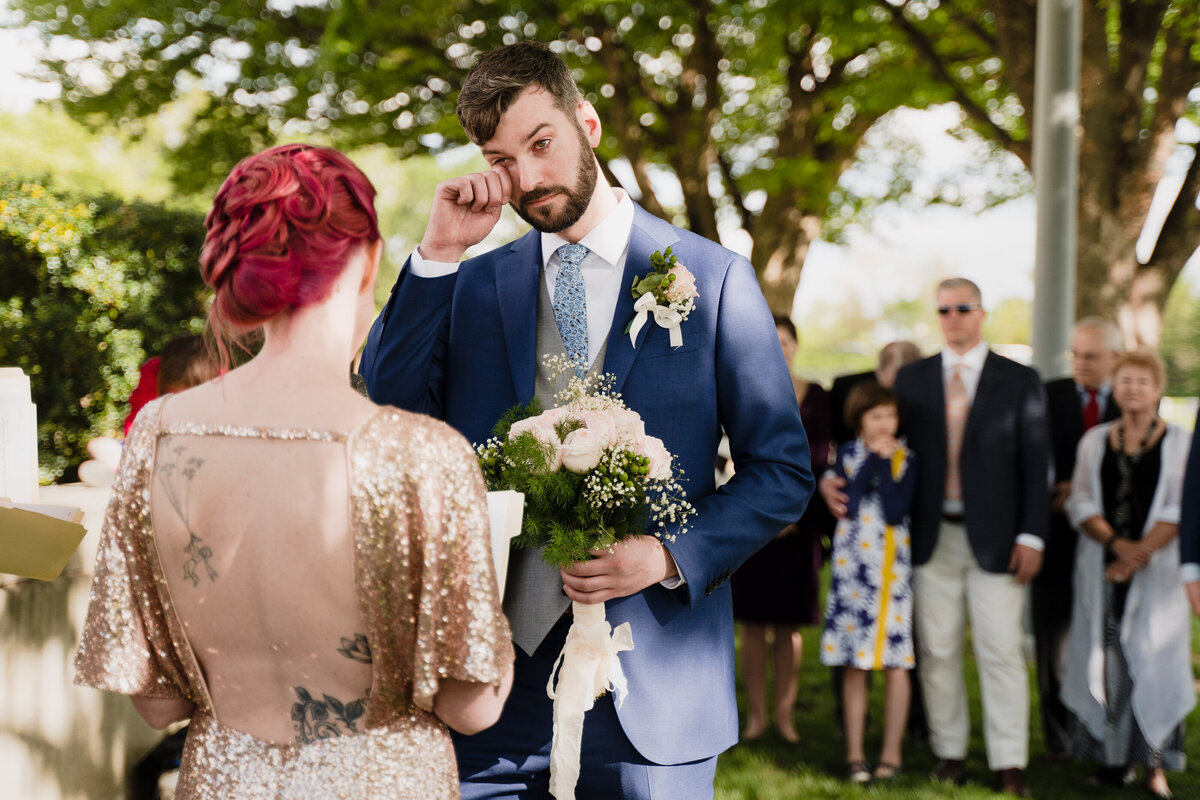 A person crying while standing up at their wedding with their partner.