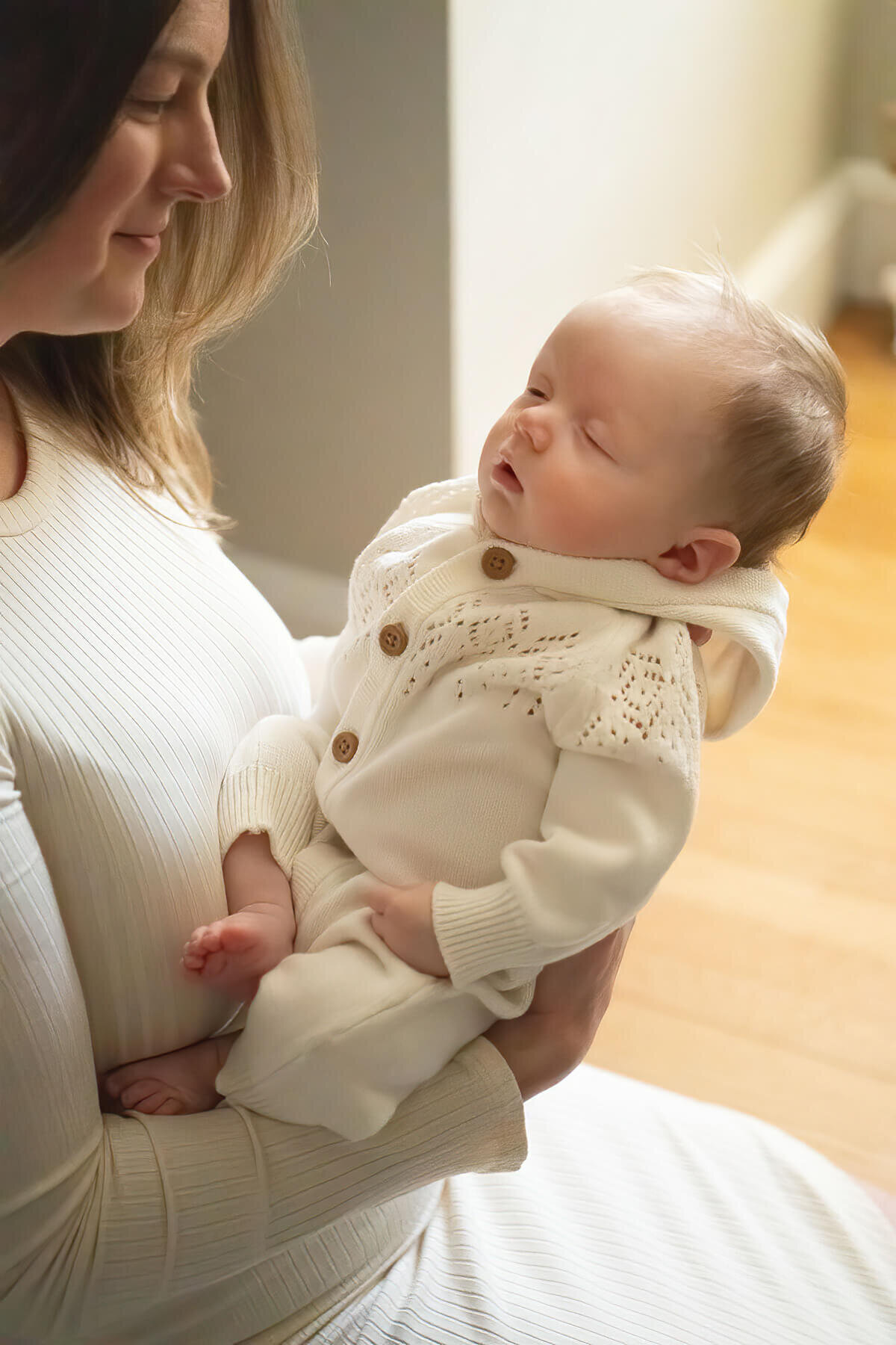 A mom holds her sleeping newborn during this Wakefield Photo session.