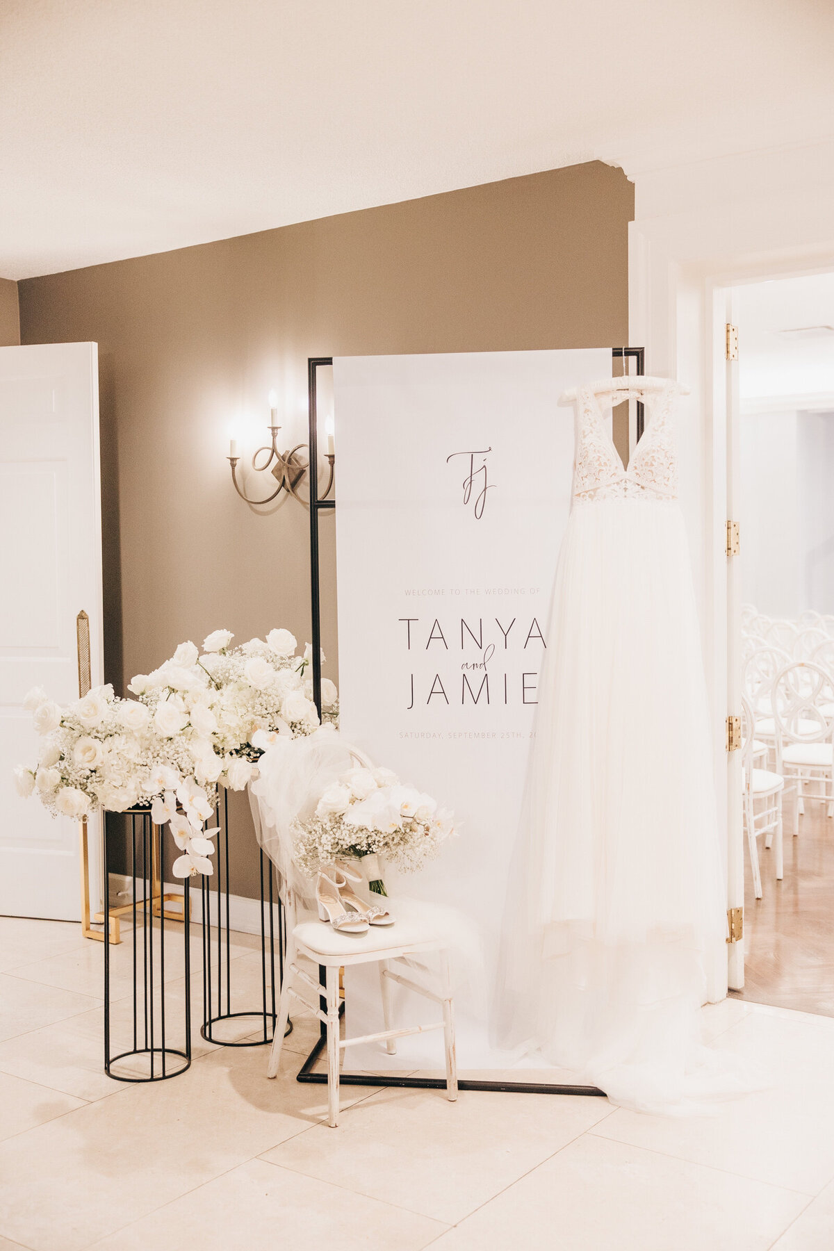 Wedding dress hanging on custom name sign at an indoor wedding