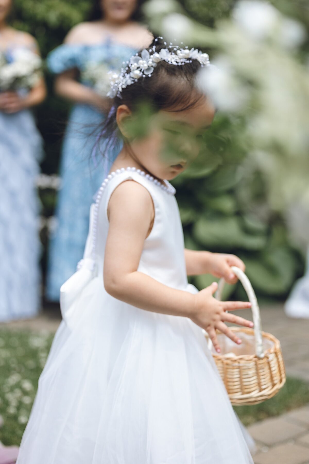 Flower girl tossing petals while walking down the aisle