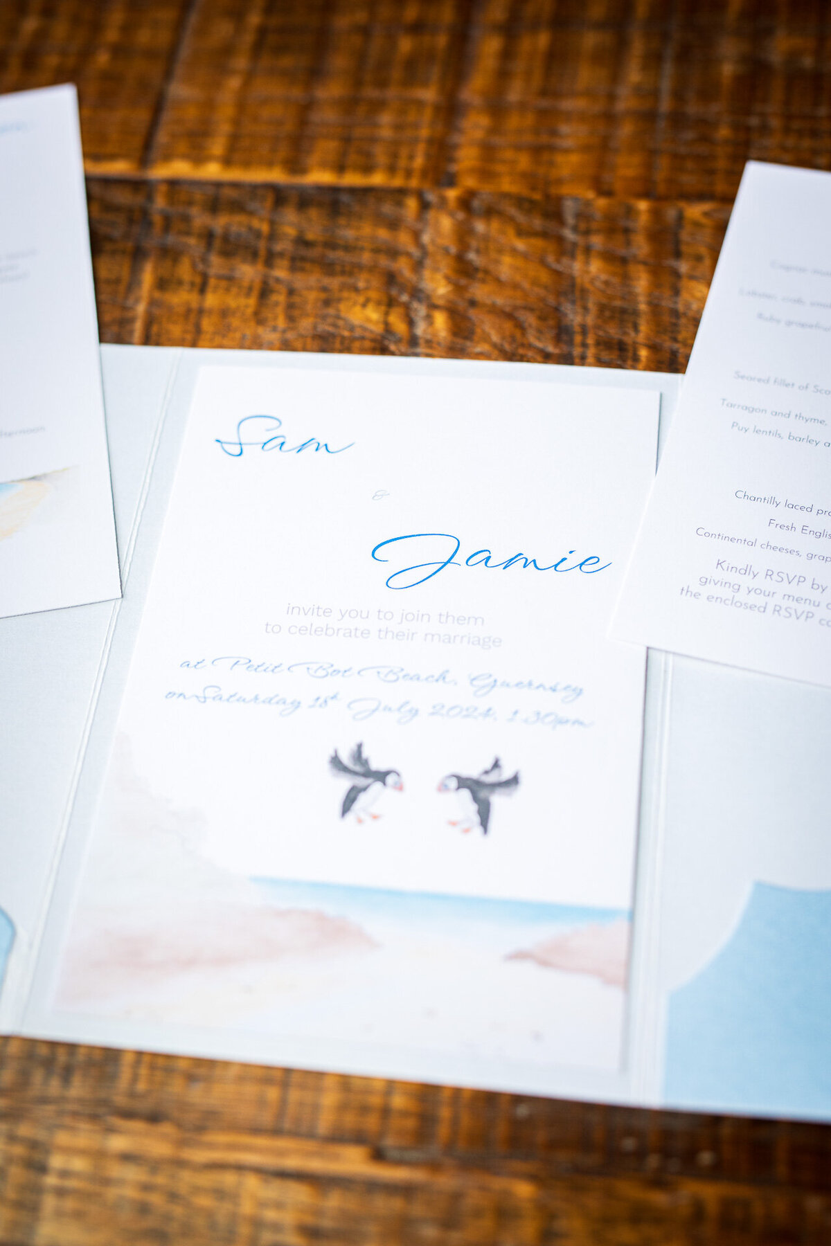 Wedding invitation featuring original watercolour print of puffins meeting over a bay