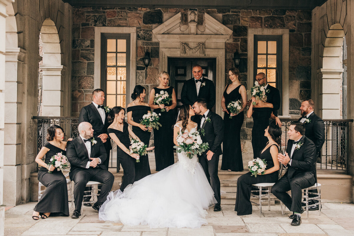 Bride and groom kissing during wedding party portraits