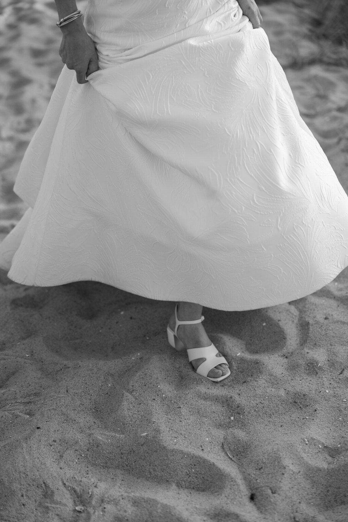 Bride walks through sand at Chatham Bars Inn.