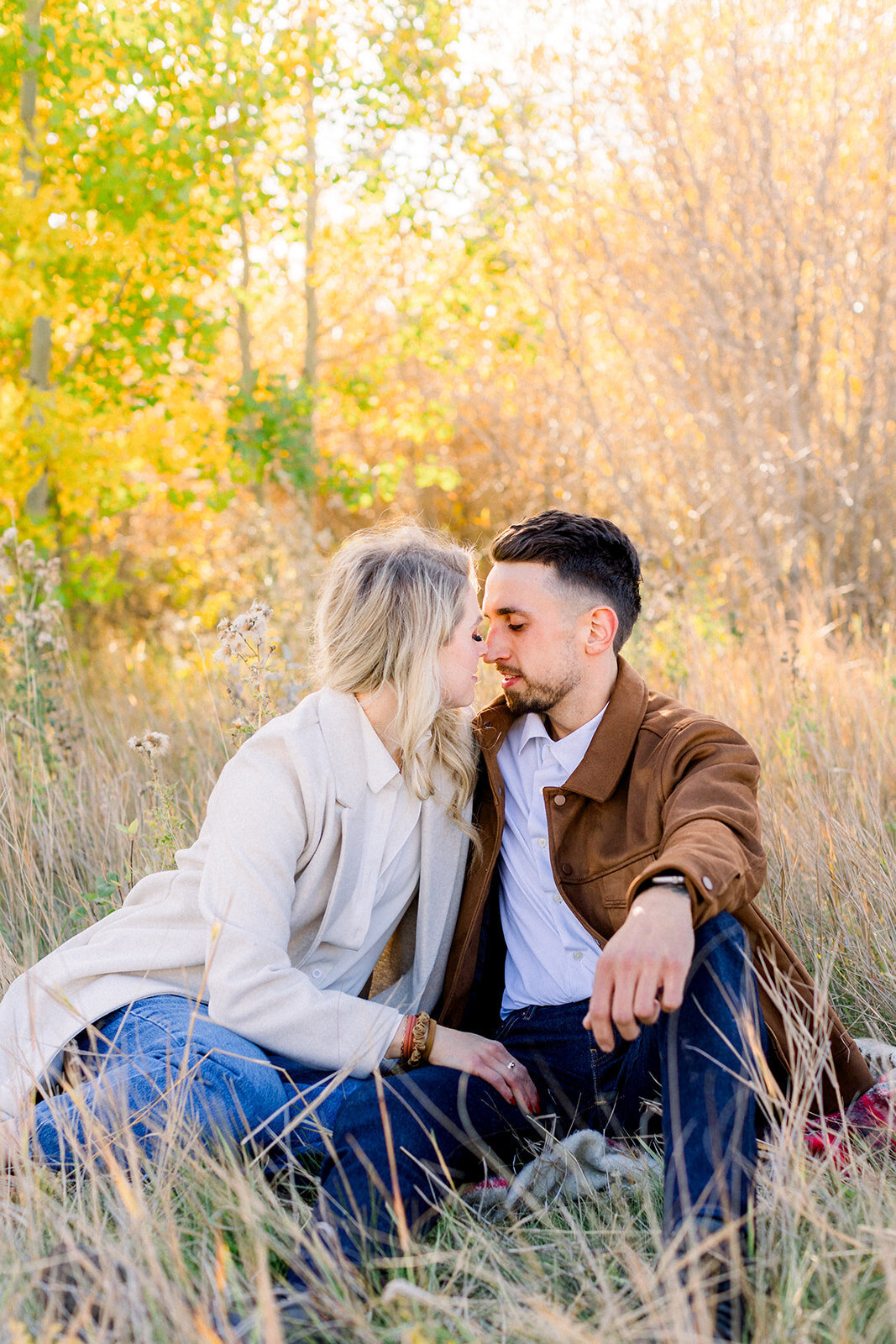 Blonde woman and brunette man about to kiss during a family photo session in Calgary, Ab.