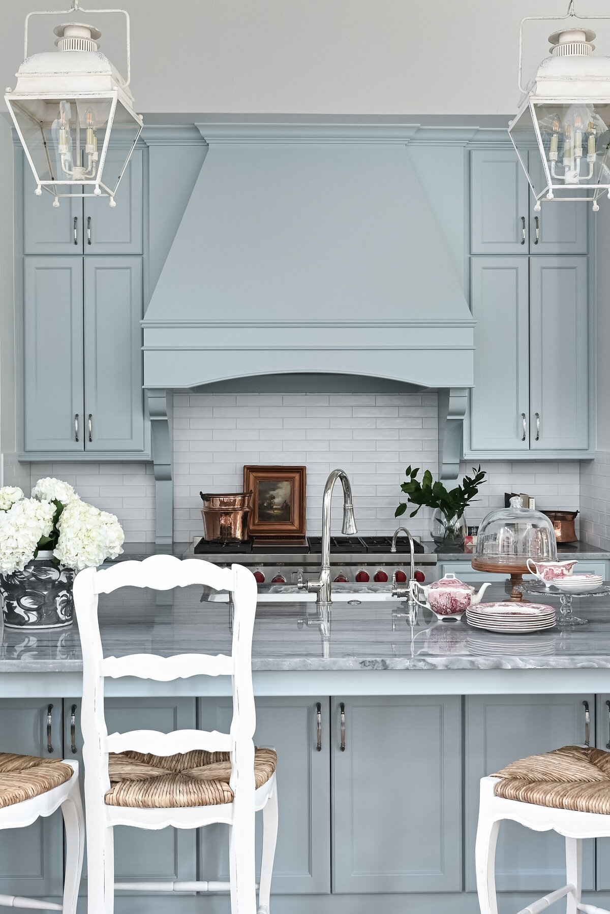 muted blue kitchen cabinets with white backsplash
