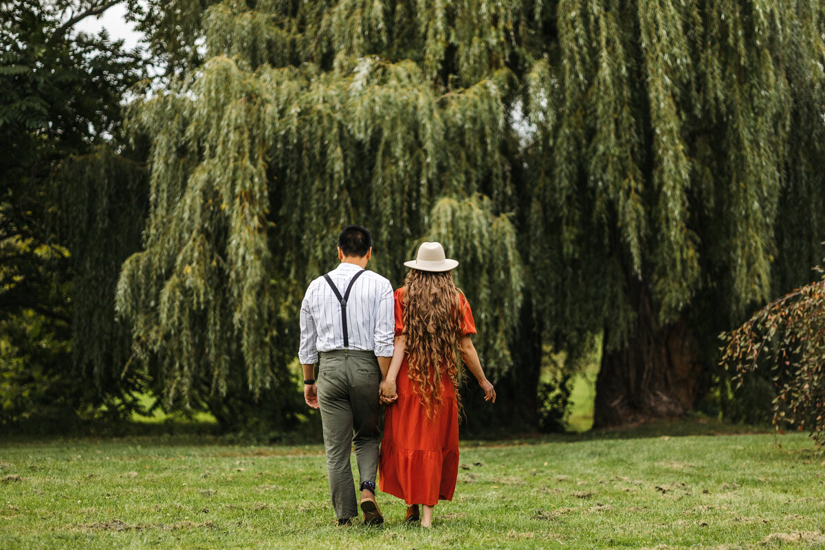 Couple walking toward a willow tree at the  dominion abortorium