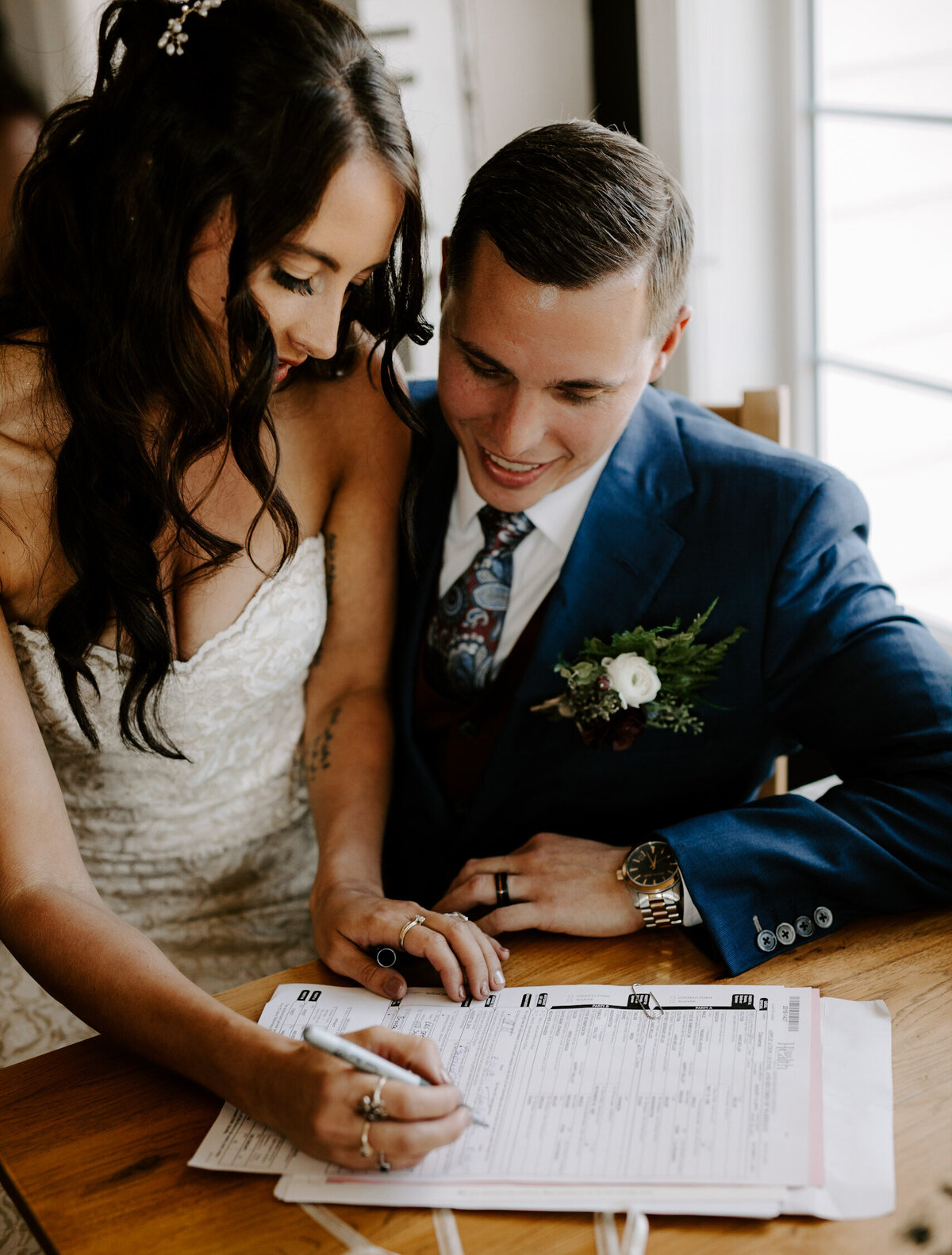 Couple signs their marriage license together after getting married