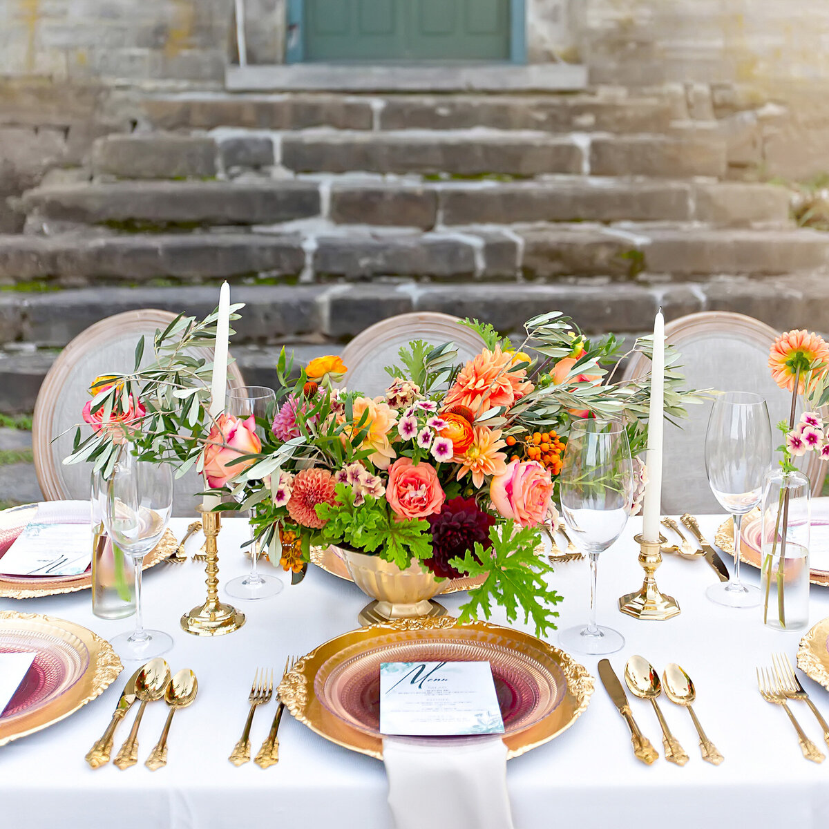 Luxury Tuscan wedding dining setup with colorful floral and gold décor accents
