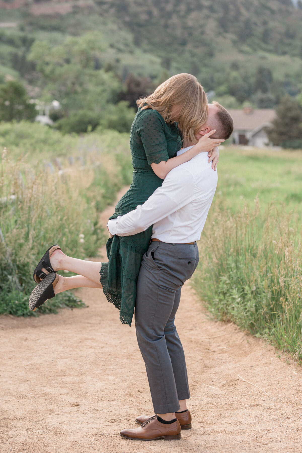 A man scoops up his fiancee and kisses her
