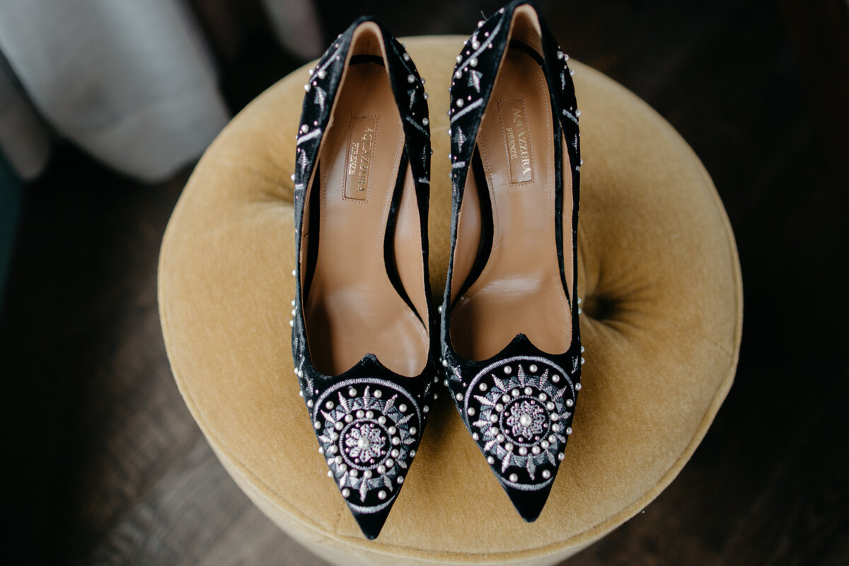 Up-close image of black heels sitting on ottoman