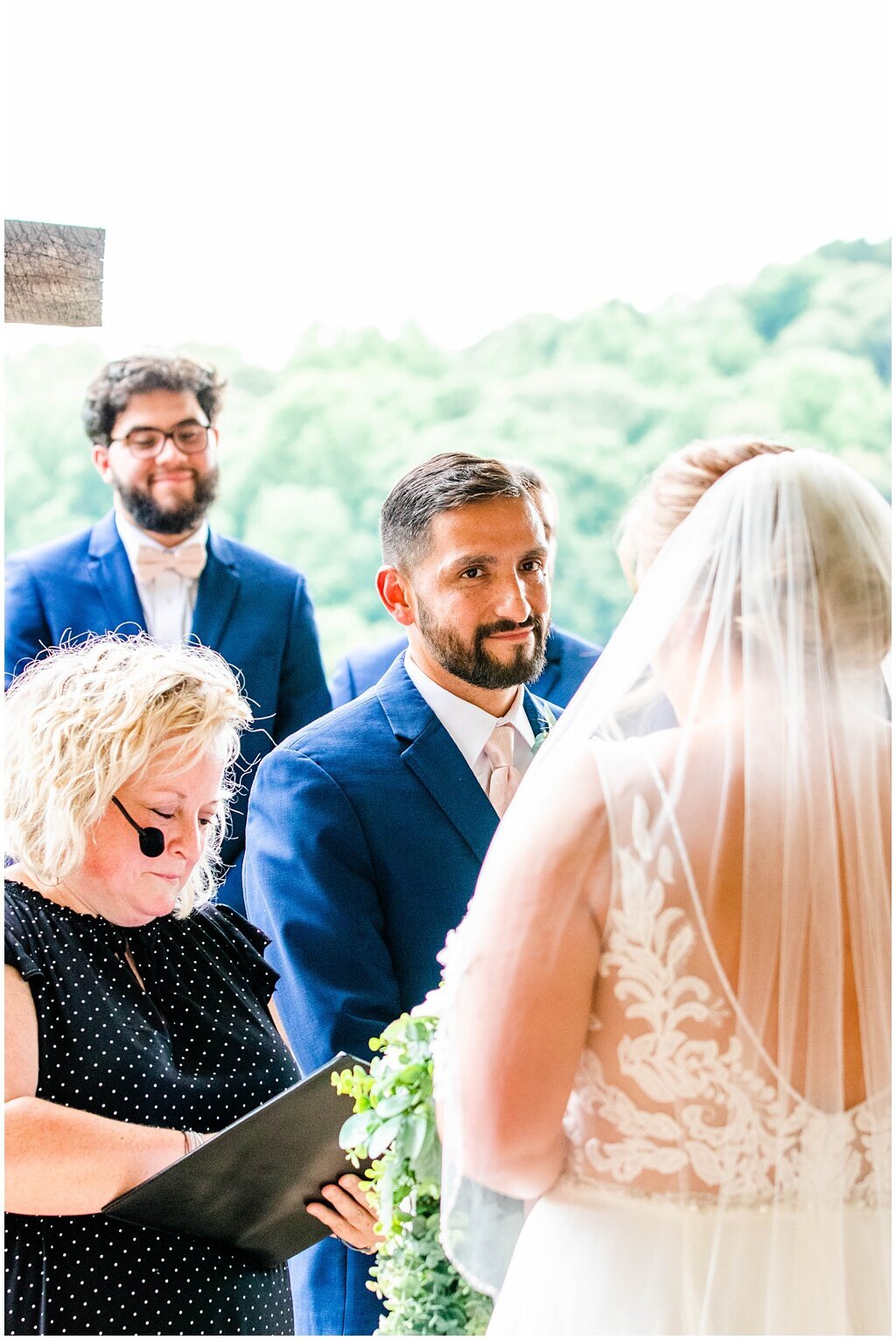 groom looking at bride while officiant reads their vows