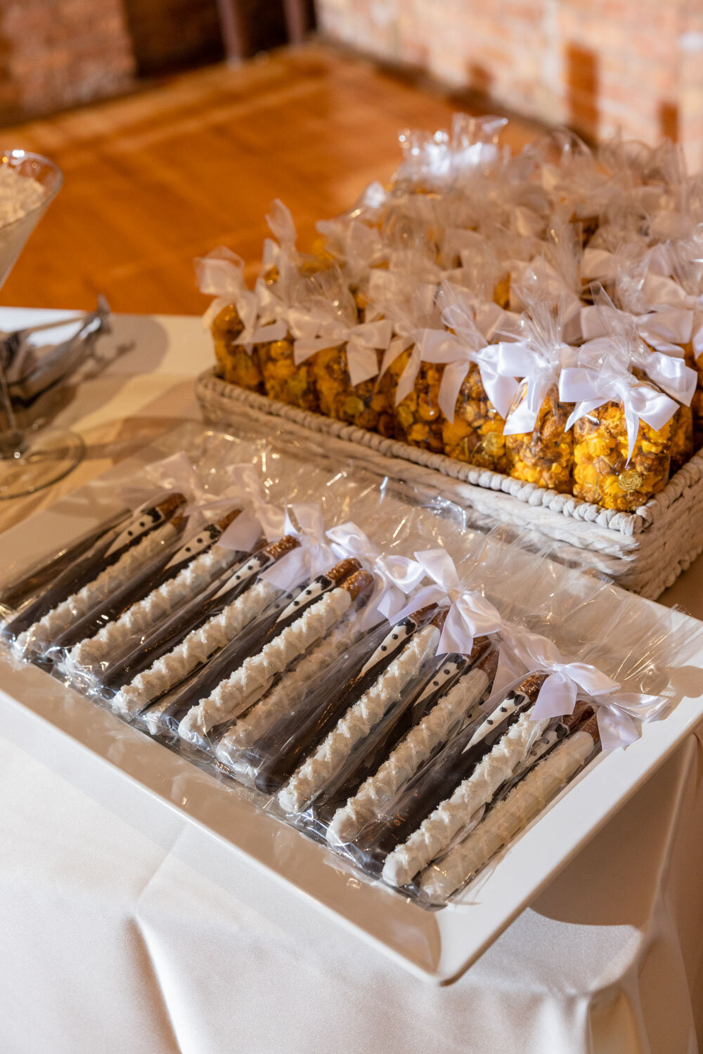 A table with a basket of popcorn and a basket of chocolate covered pretzels