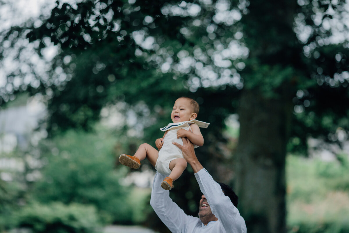dad-lifting-up-baby-boy-in-garden