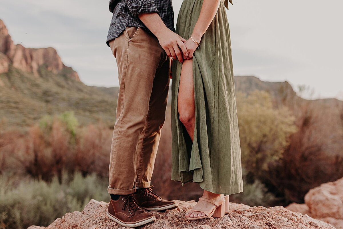 Close up photo of man and woman’s legs as they face each other for engagement photos