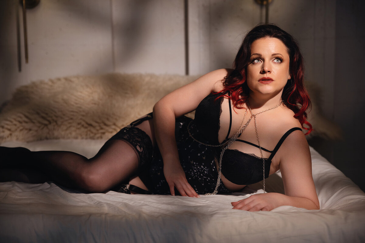 Professional boudoir portrait of a plus size woman wearing black lingerie