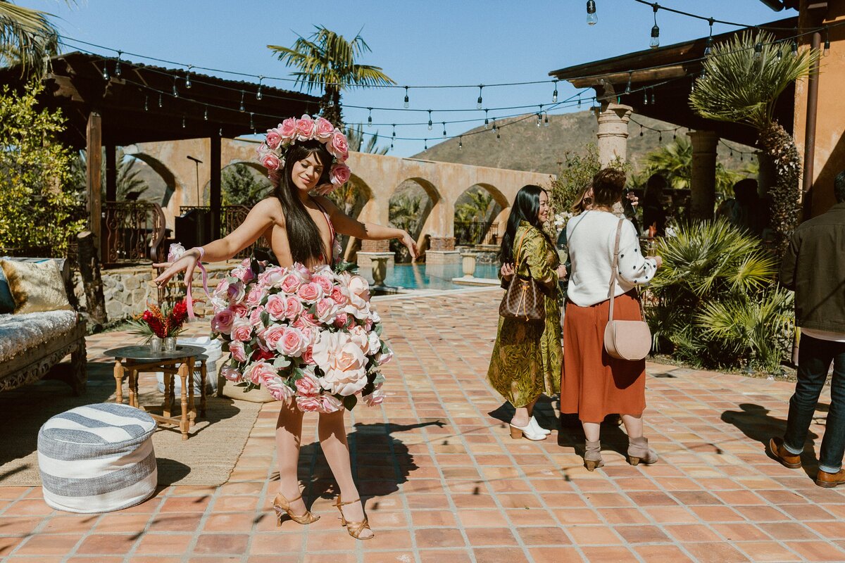 ballerina in a rose tutu dances around a party at the bachelor mansion pool