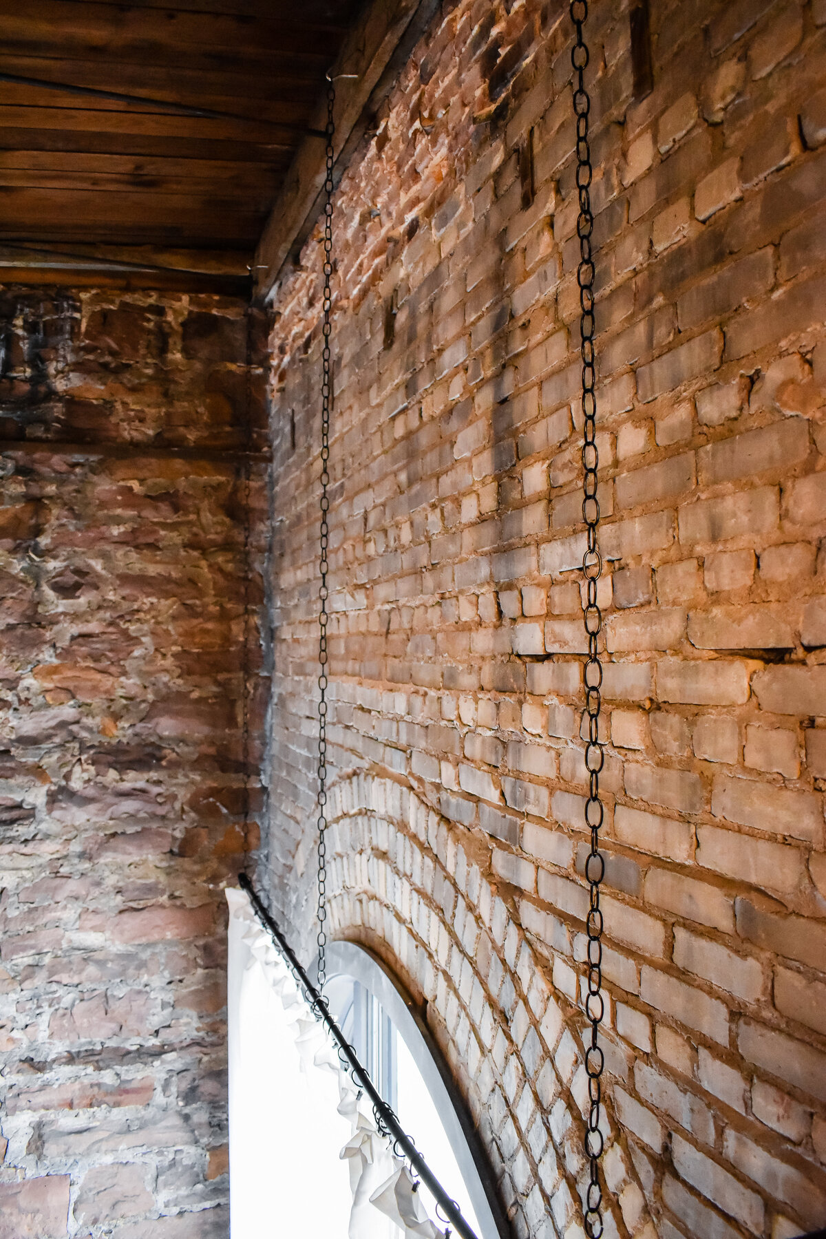 A photography studio with tall ceilings and brick walls