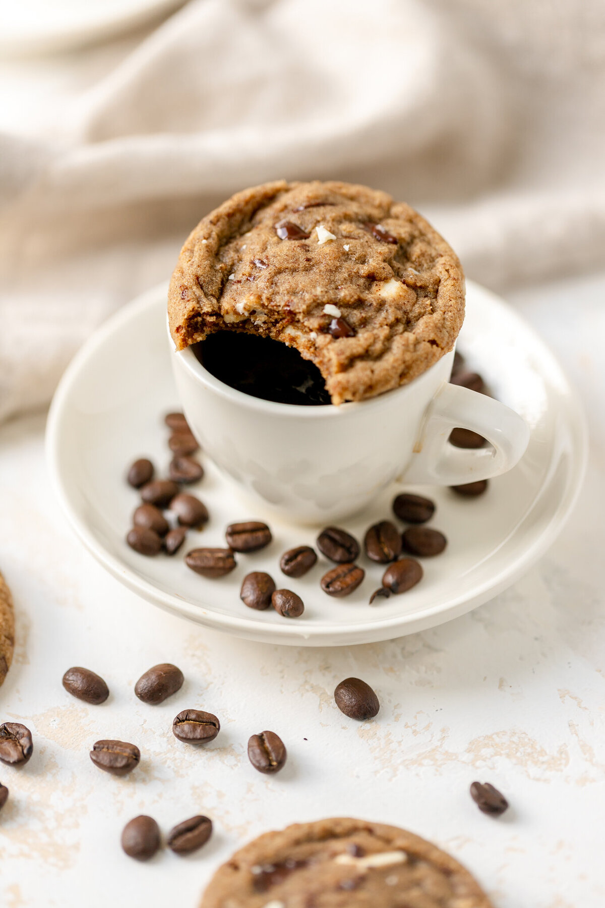 a cookie sitting on top of a mug of coffee