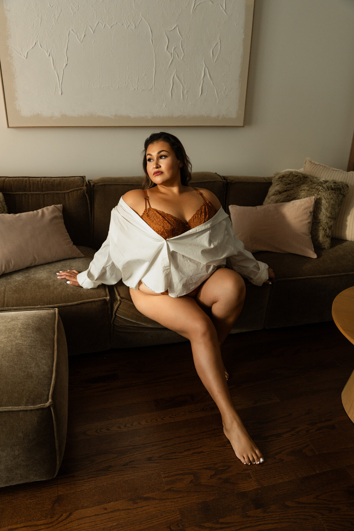 woman with a open white shirt on sitting on a couch