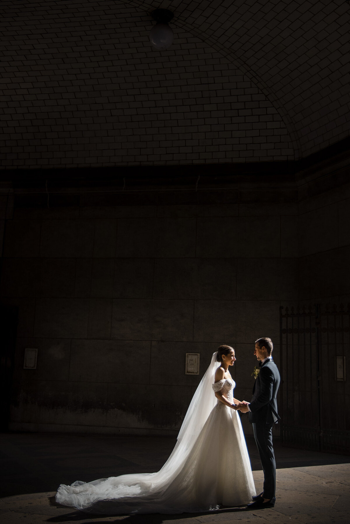 A bride and groom pose in dramatic light at a Beekman Hotel wedding