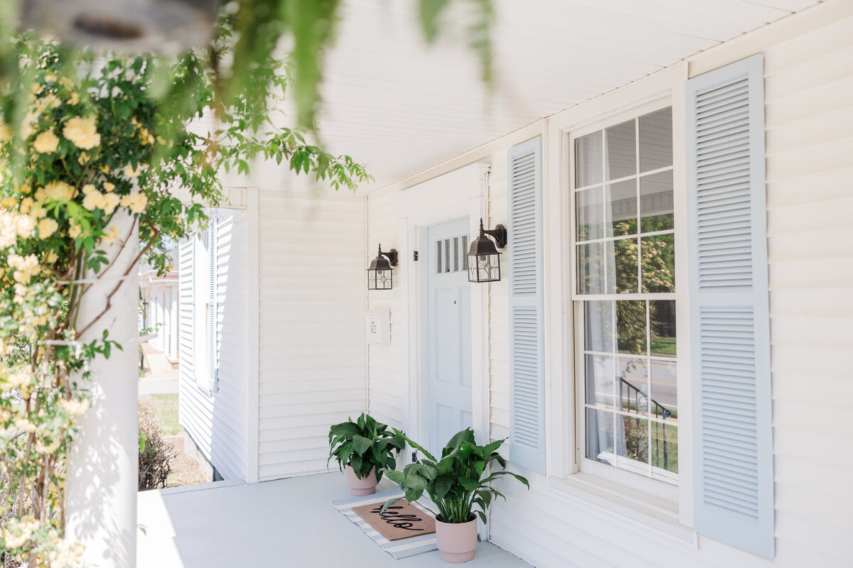 the porch of a blue and white house that has been converted into a photography studio