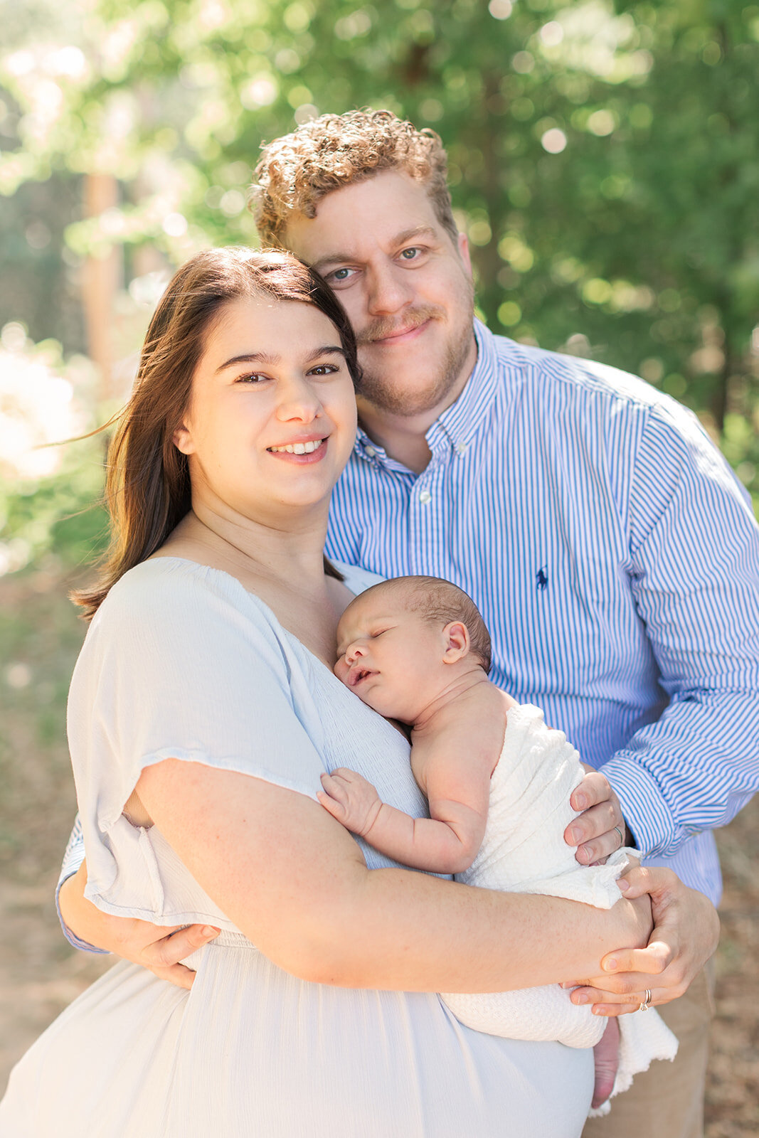 New parents beaming during newborn photography session