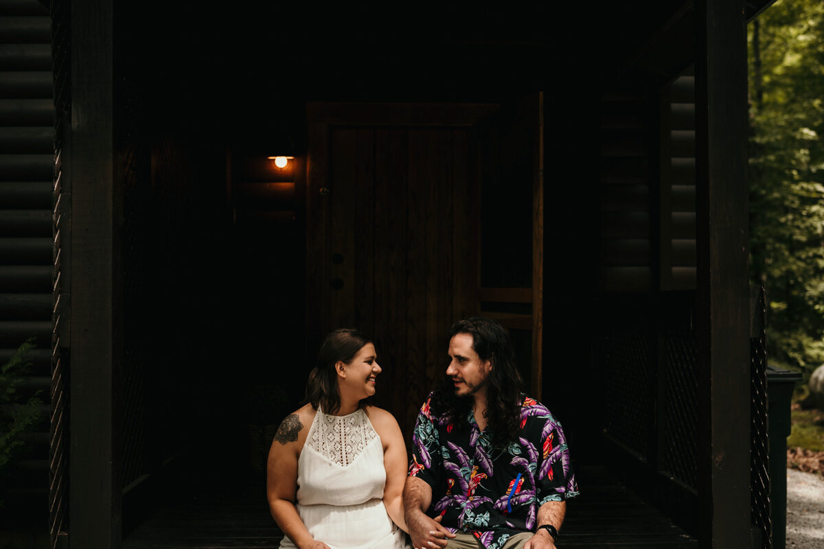 Couple laugh on porch of Hocking Hills cabin