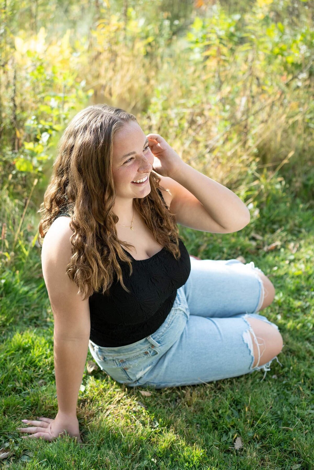 senior-girl-in-sunny-field-with-hand-in-hair