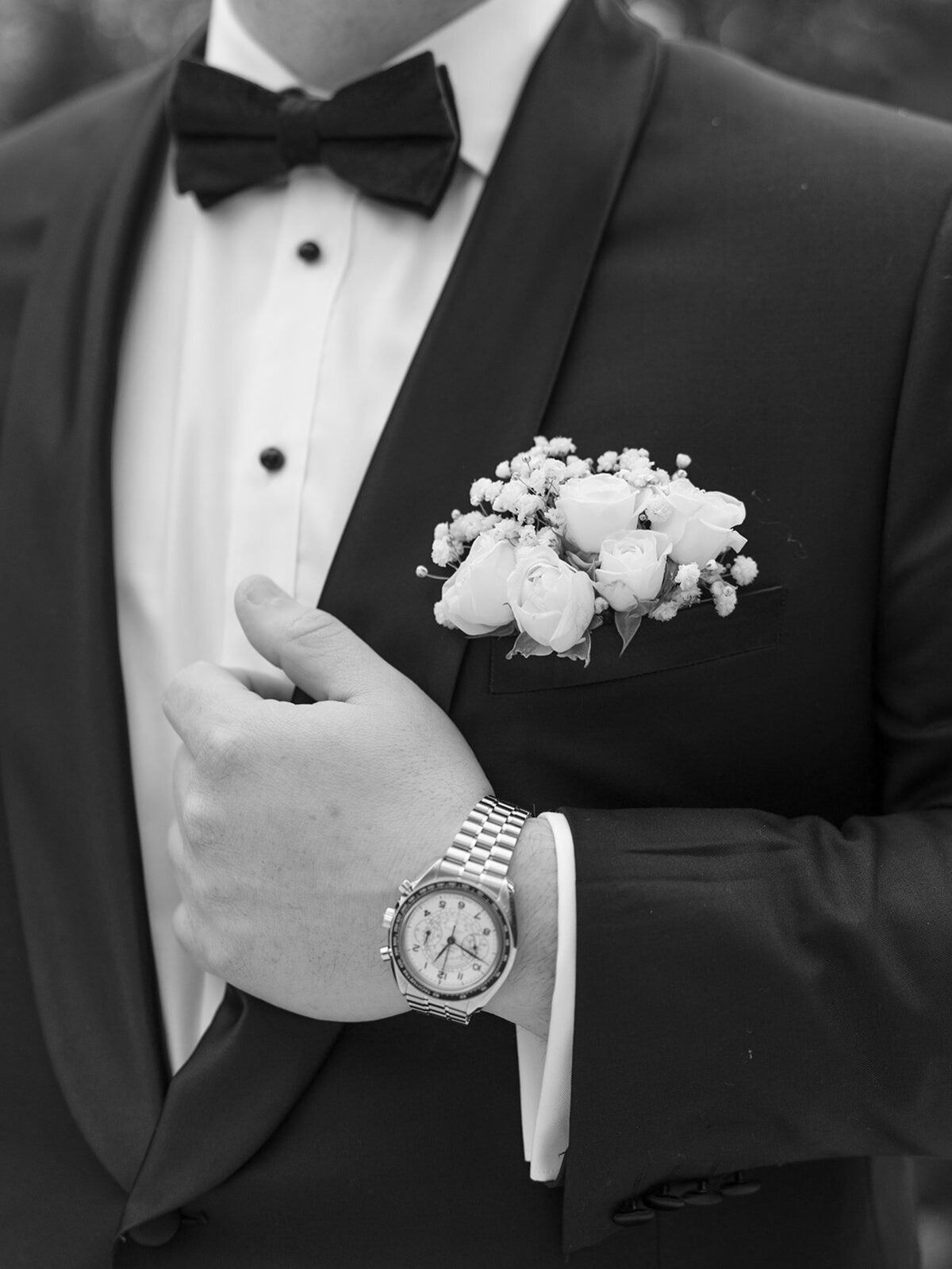 Black and white detail of a groom in a tuxedo