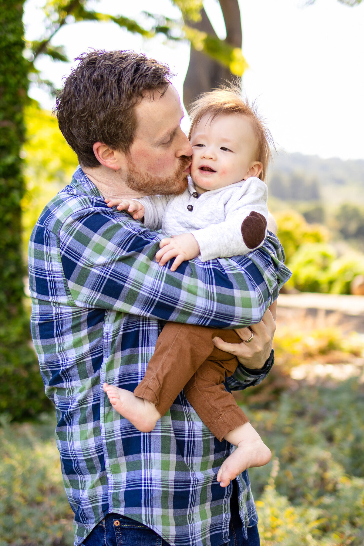 San Francisco Peninsula family photographer candid moment Father kissing baby 