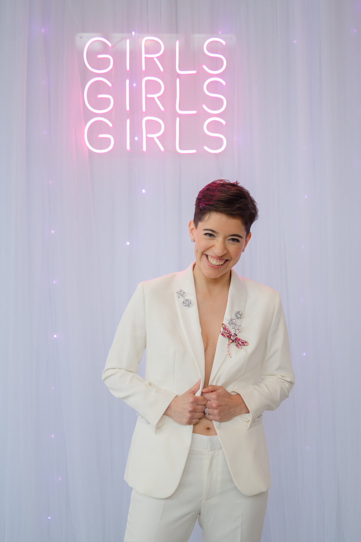 Bride in suit with "Girls, girls, girls" sign