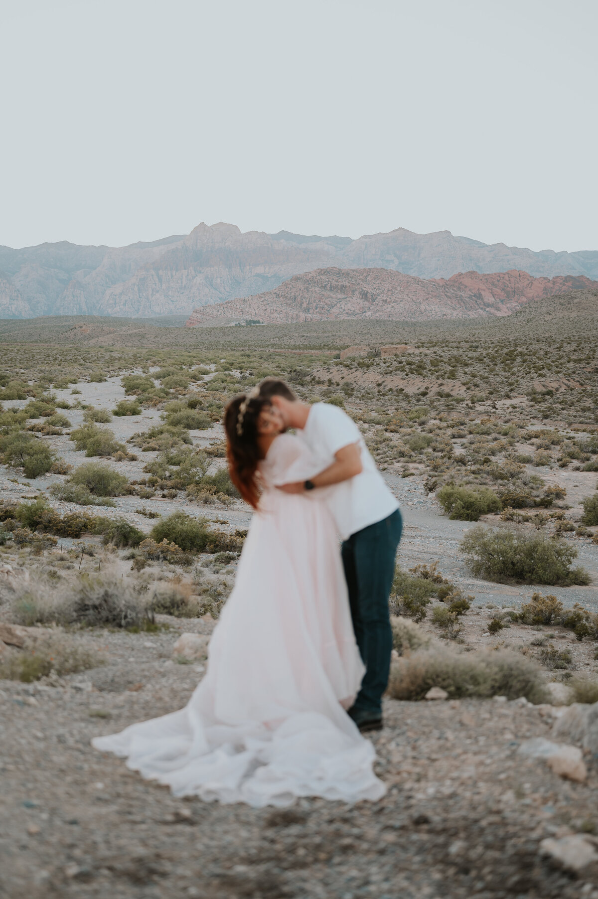 a cute couple in red rock canyon las vegas posing for their wedding photographer