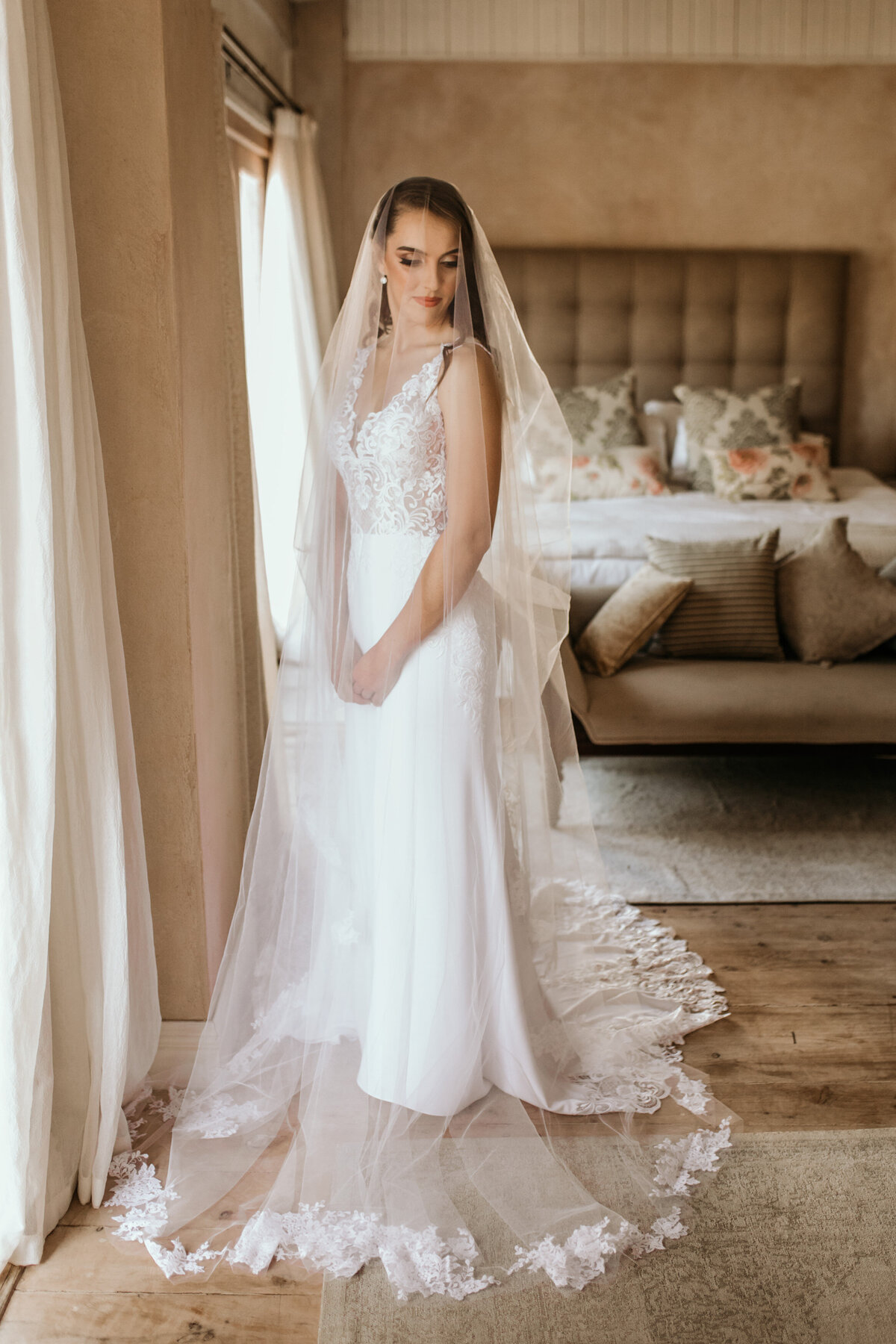 Bride draped underneath her veil while in her dressing room. 