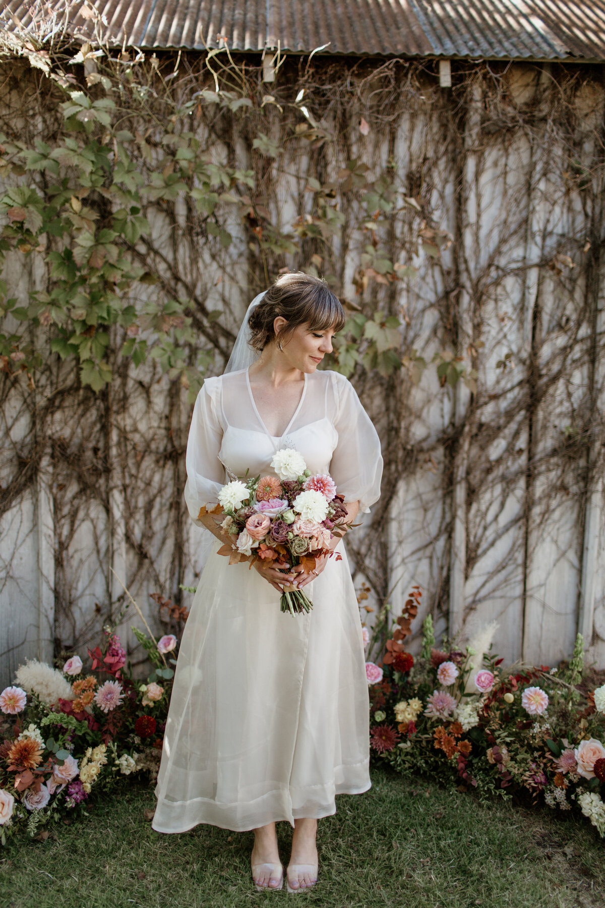 Bride in tea length dress surrounded by florals at Ingenhuett on High in Comfort Texas. Captured by Fort Worth Wedding Photographer, Megan Christine Studio