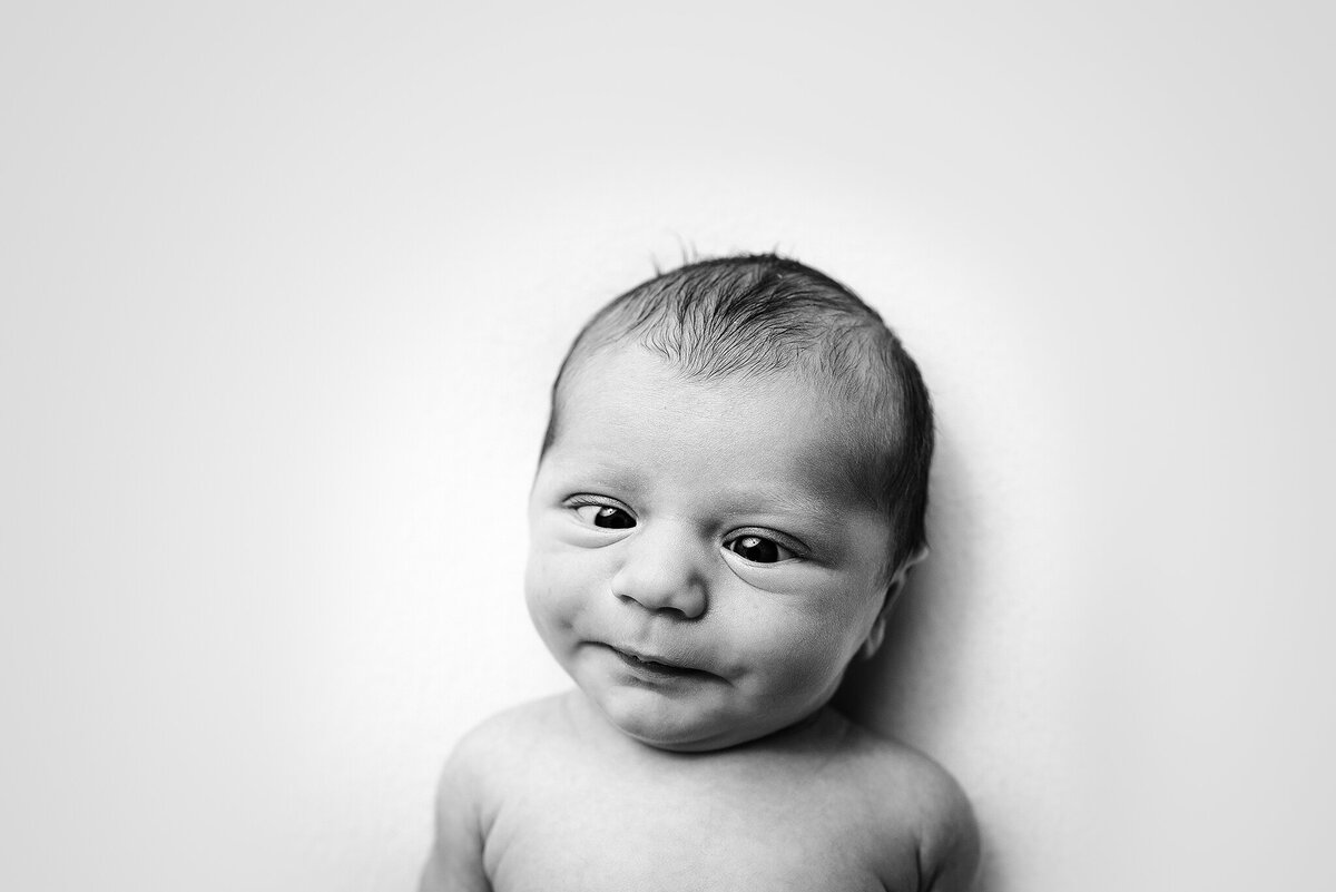 Expression shot of newborn with eyes crossed in black and white in Jacksonville, Florida.