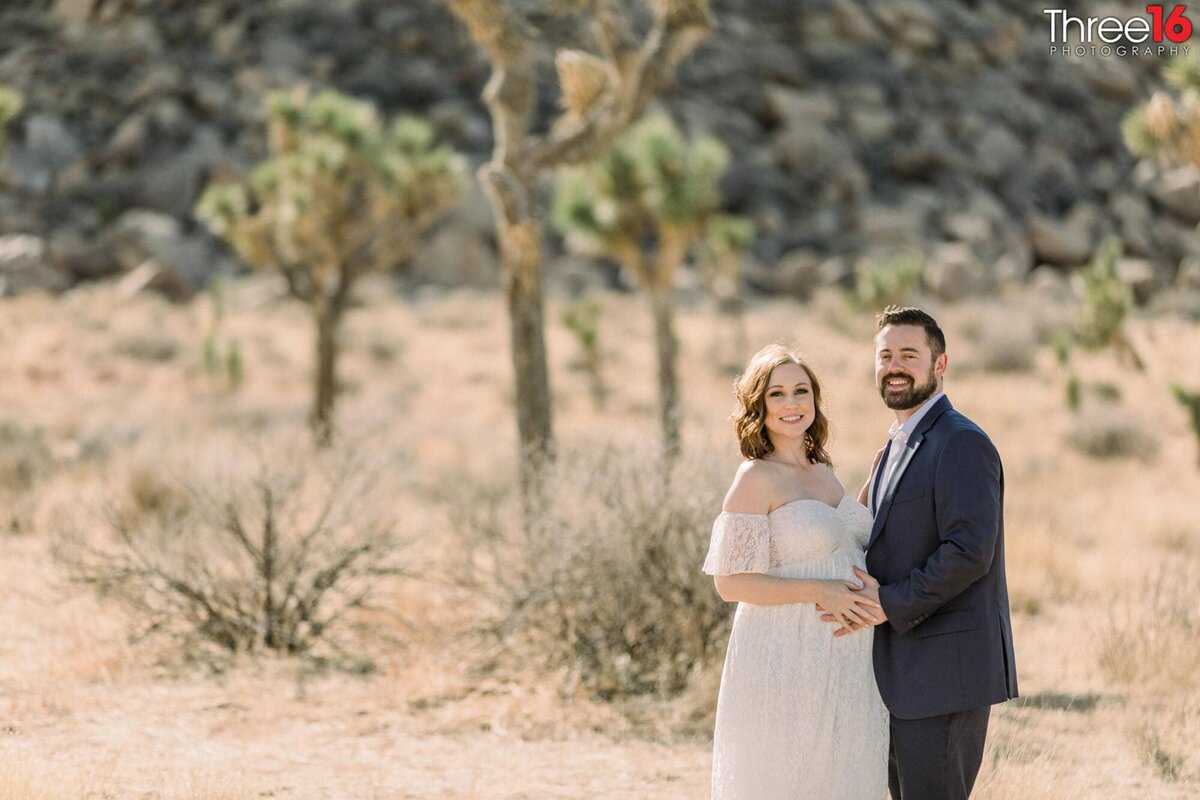 Maternity couple pose for photos in the desert