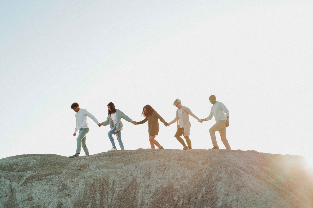 family holding hands walking on rock