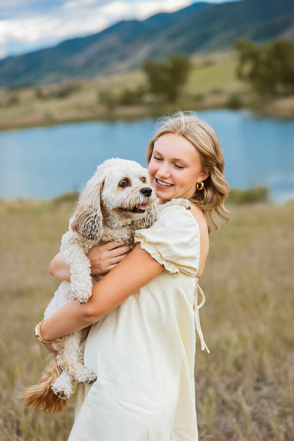 Girls holds and looks at her dog at a Denver park.
