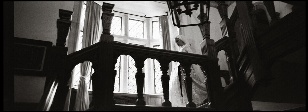 Black and white film photo of a groom in a western hat in new york city 