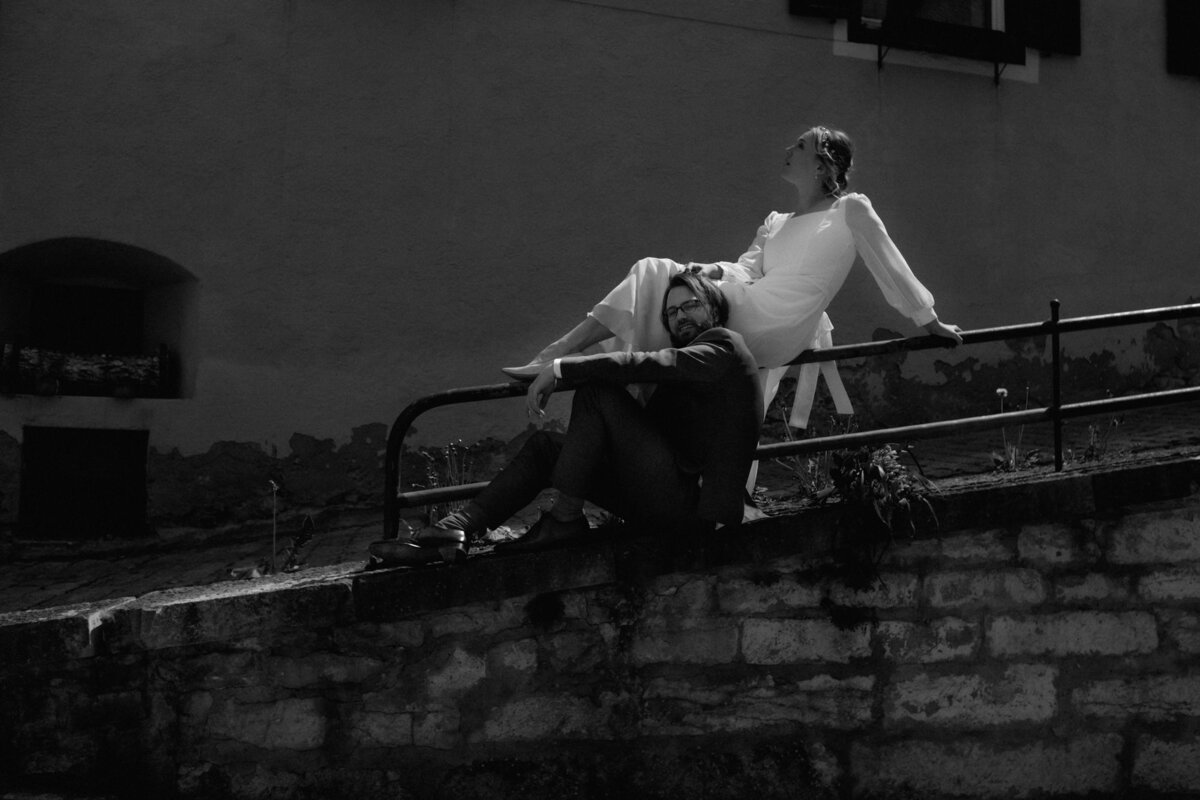 An einem leichten Abhang posiert das Paar. Sie liegt auf einem Geländer, er sitzt davor.