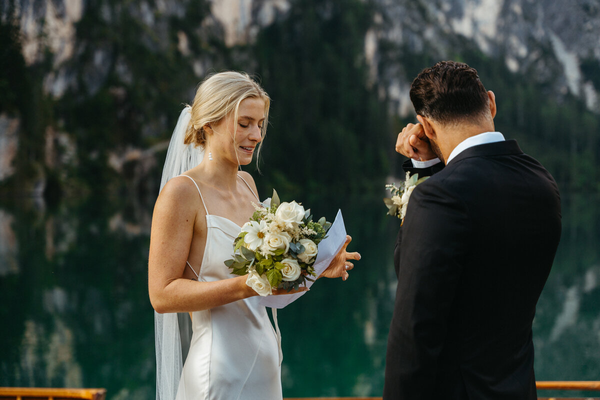 Bride and groom smiling while exchanging vows on dock