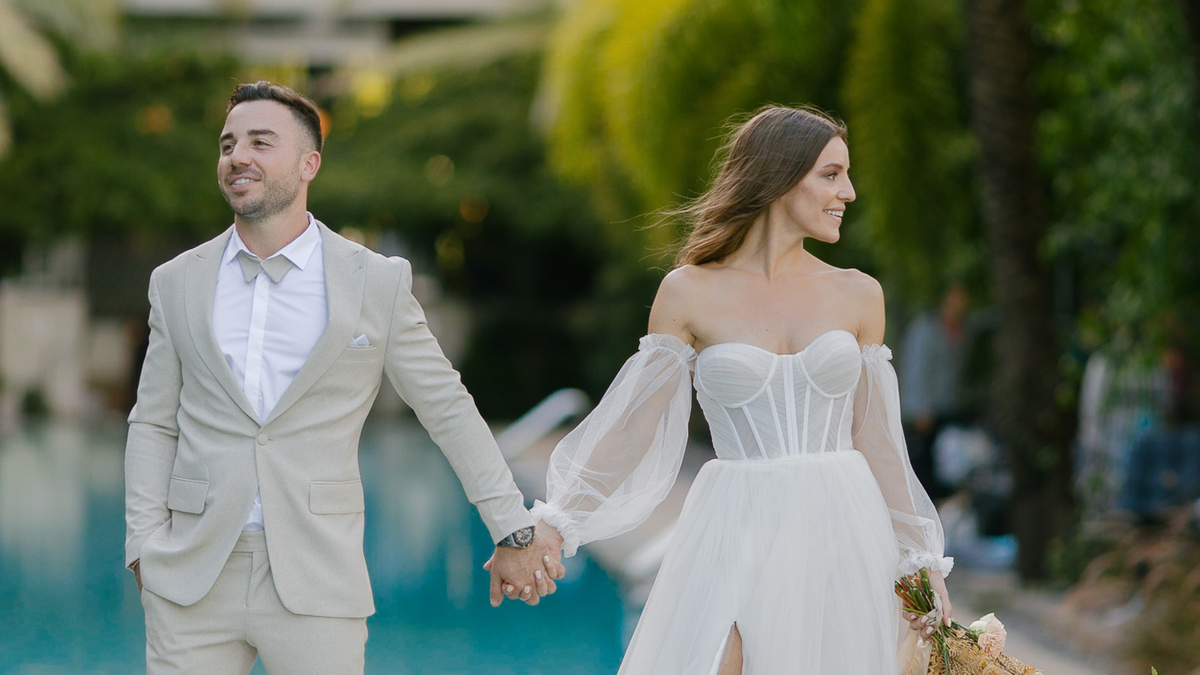 Elegant bride and groom holding hands by the poolside in Miami, captured by Claudia Amalia, a wedding and lifestyle photographer based in Miami and Florida Keys, South Florida. Specializing in destination weddings.