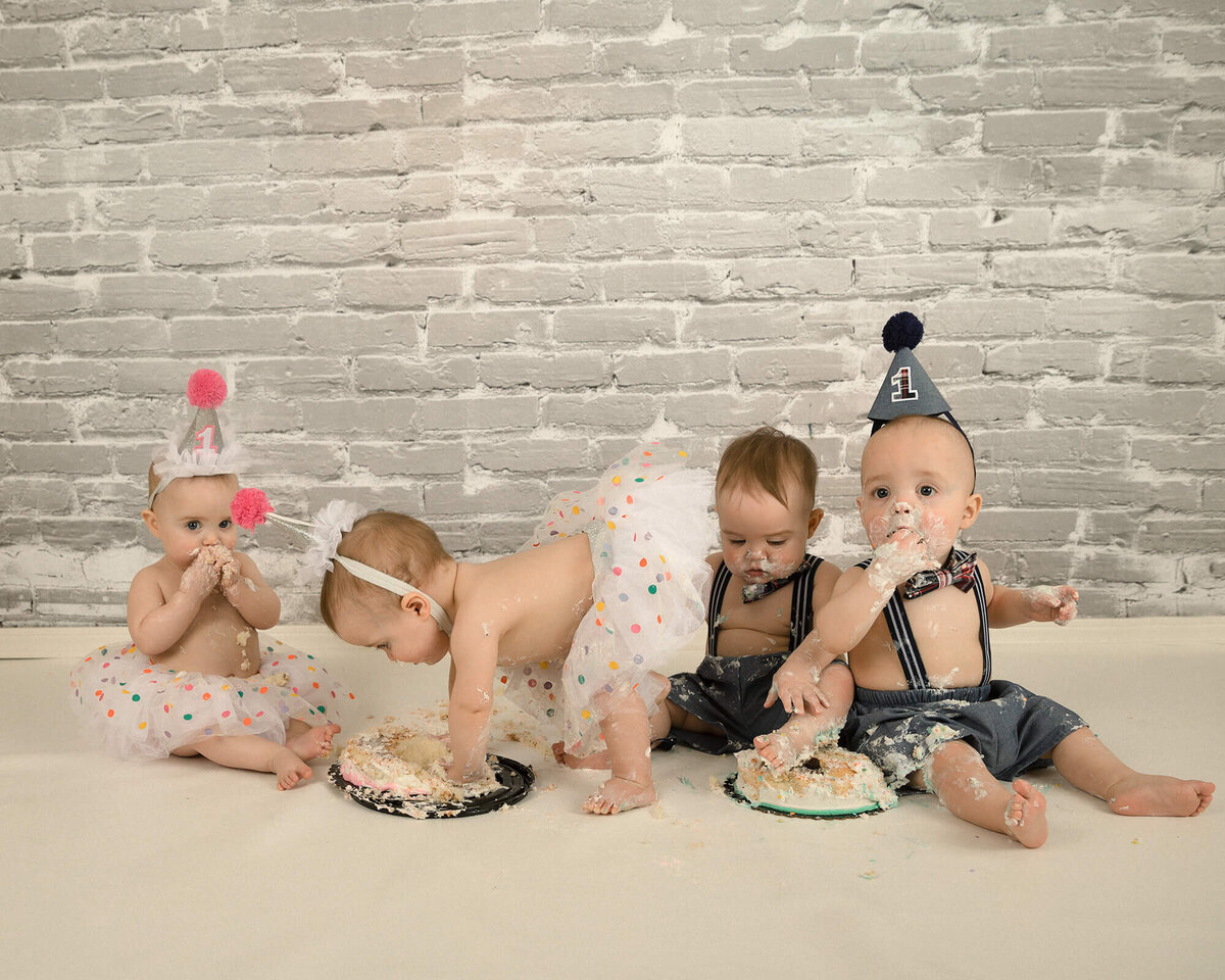 Quadruplets at the 1 year old cake smash making  a mess.