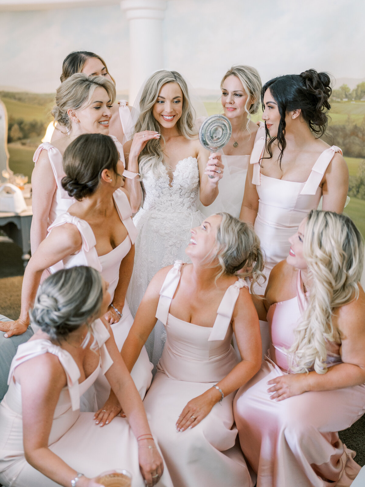 The bride holding up a mirror along with her bridesmaids does a playful and fun photoshoot at a Chateau Noland Wedding 