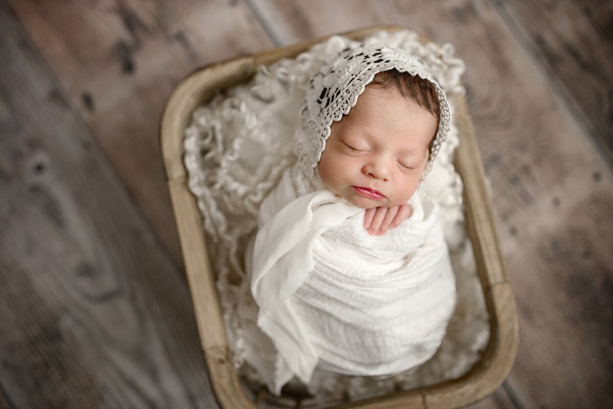 newborn-girl-wearing-white-bonnet